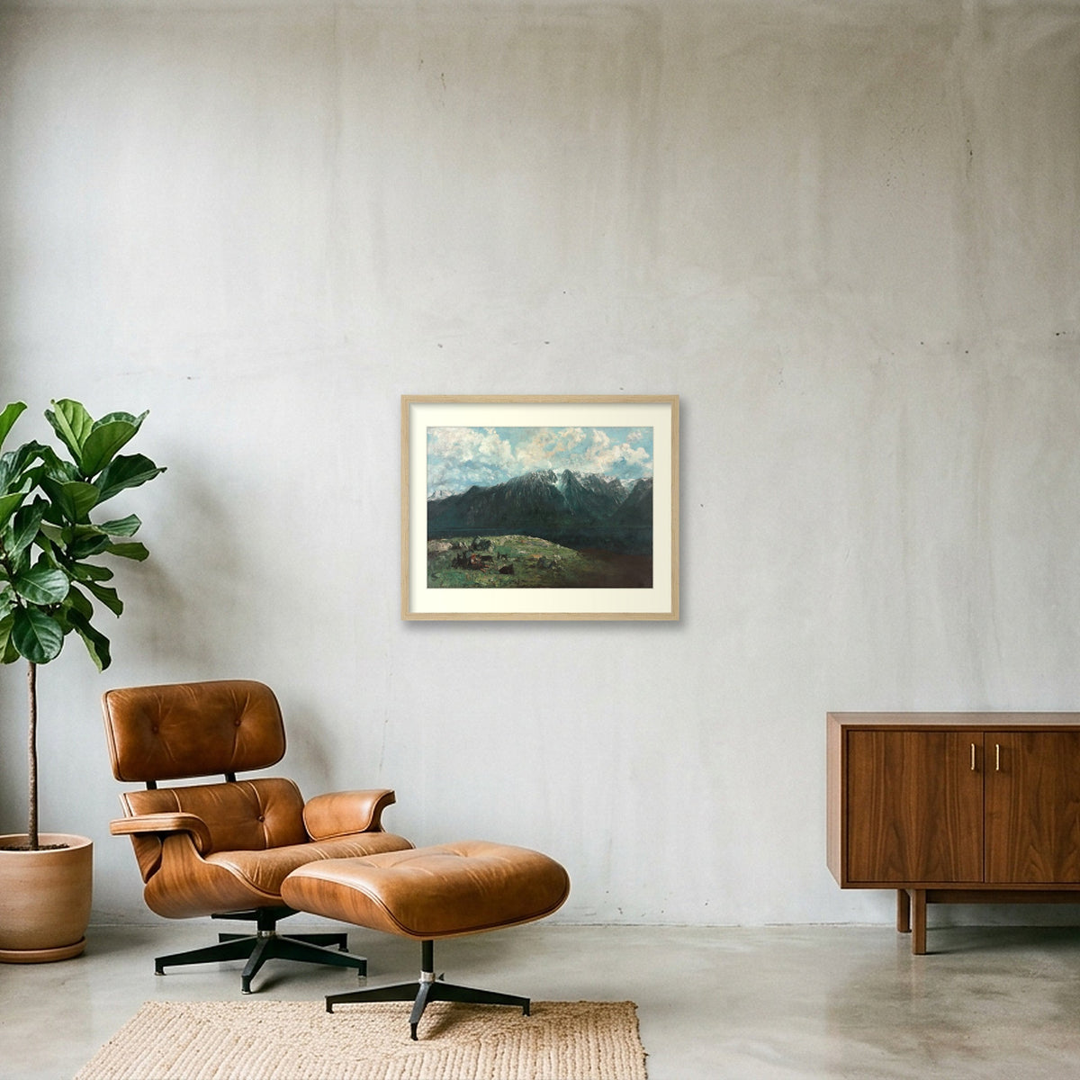 Digital room preview of Courbet — Panoramic View of the Alps with an ivory mat and oak-veneer frame, beside a brown leather chair.